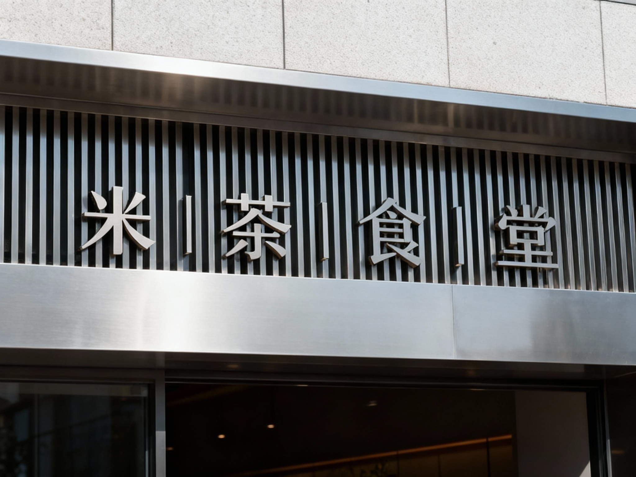 高端金属格栅门头特写，采用哑光不锈钢板材无缝拼接格栅，底板平整干净，LOGO以激光切割镂空工艺嵌入式安装于格栅中央，无外露连接件，白天自然光照射，金属质感细腻，凸显现代简约大气