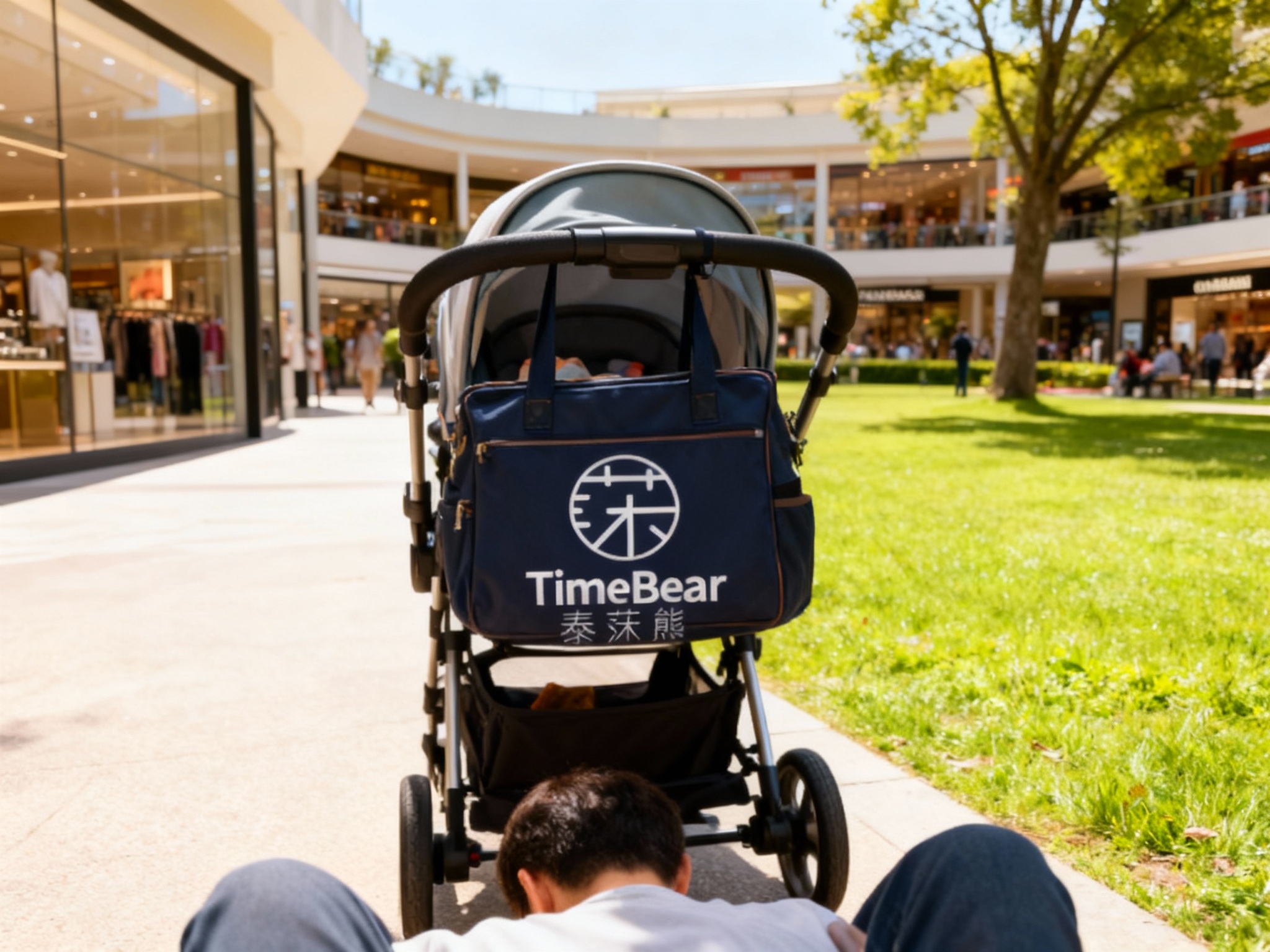设计社交分享场景图（POV视角）。第一人称视角低头看，推着一辆设计时尚的婴儿车，把手上挂着印有（智能提取参考图中的LOGO主体并去除原背景）的妈咪包。背景是高端购物中心或阳光明媚的公园草坪。画面色彩明快，充满时尚辣妈的生活气息。
