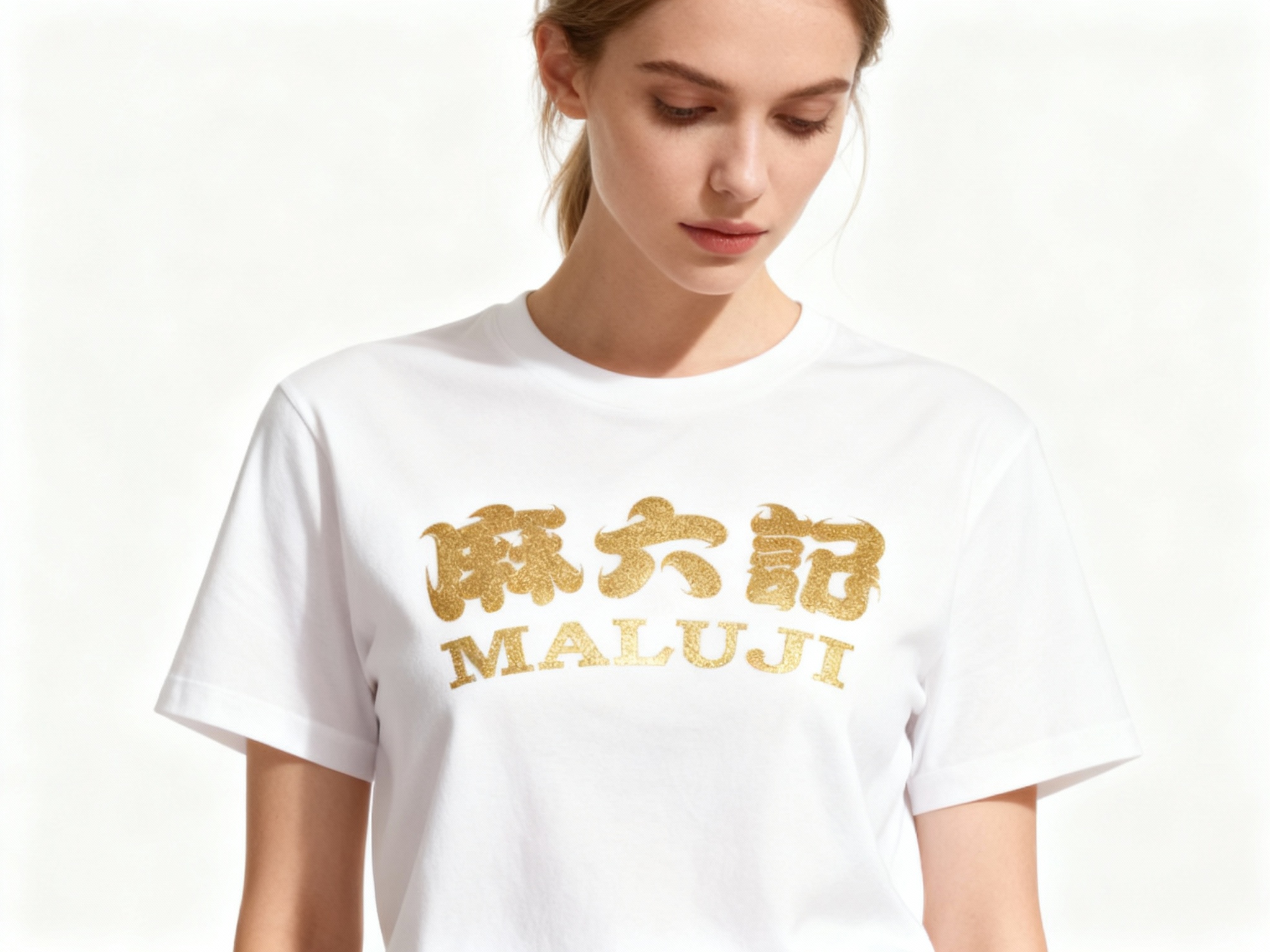 提取参考图的LOGO单独呈现，改为金色，25岁欧洲女性模特，穿纯白重磅T恤，金色LOGO采用烫金工艺印制，金属光泽细腻不浮夸，正面柔光拍摄，光线均匀照亮T恤表面，凸显LOGO与面料的质感对比，模特自然垂眸，背景为纯净白色，画面简洁高级，符合奢侈品广告调性
