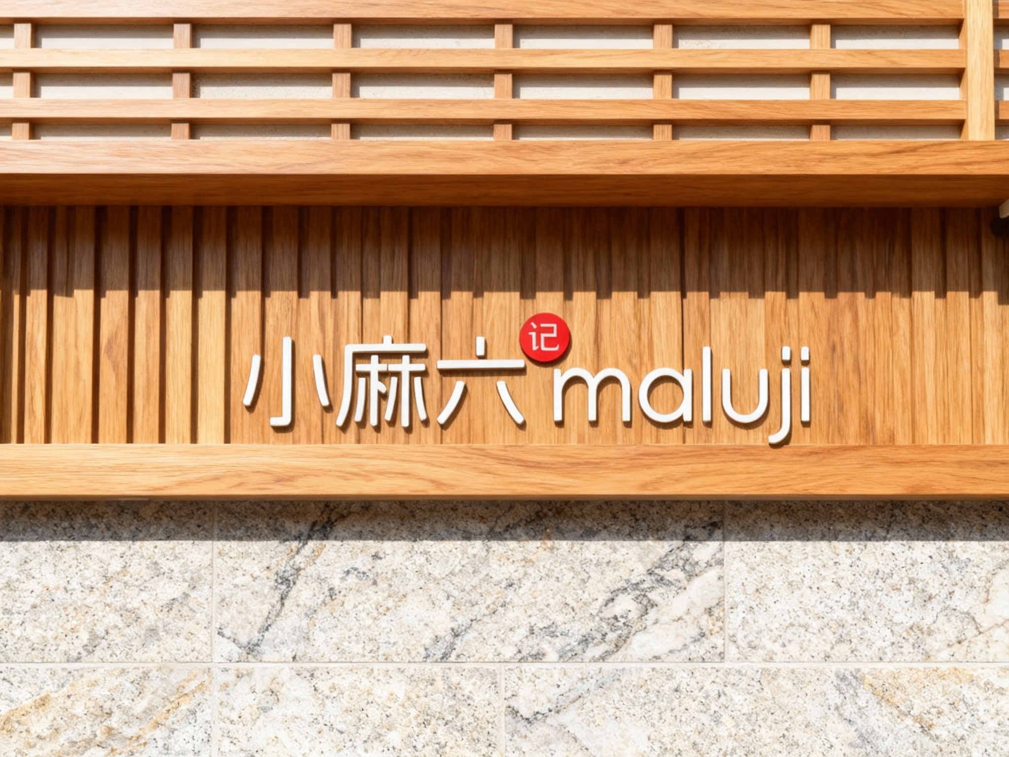 木质格栅与石材结合门头特写，上部为进口白蜡木格栅经哑光清漆处理，无缝拼接成型，下部为天然大理石板材无缝拼接墙面，LOGO以激光雕刻+填色工艺呈现于木格栅中央，白天自然光照射，木纹与石材质感相得益彰