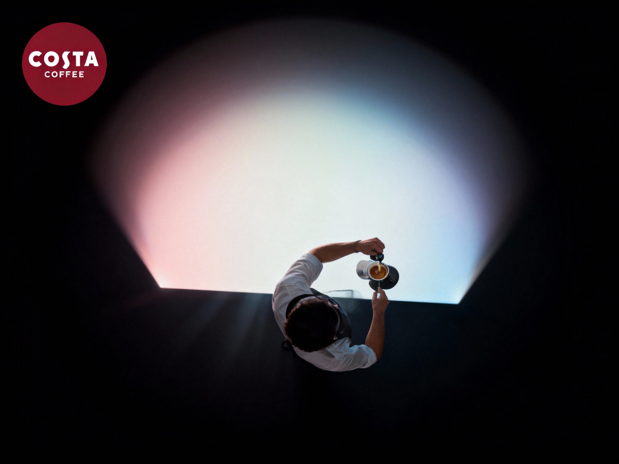 设计品牌宣传海报，画面干净，（将参考图中的LOGO ）位于左上角或右上角（根据实际情况设置），大师作品，电影海报，超高质量，超精细，高级英文排版，摄影，丁达尔光效，朦胧，俯视，远景，极简，简单，极简风格，大面积留白，James Turrell，背景是咖啡师冲泡咖啡的景象，压迫感，超现实主义+极简主义 + 简单色块+ 马卡龙配色+ 摄影艺术 + 细节丰富+ 封面美学 +黑色背景+电影级照明，4k高清，排版简洁有视觉冲击力，符合社交平台分享特性。